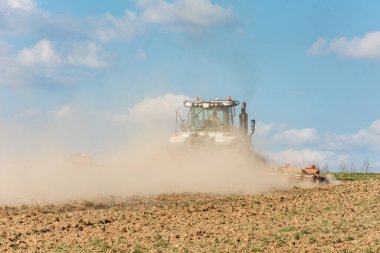 Baharda, bir çiftçi modern bir traktörle harrows çeker ve pancar eker. 2021 mahsulü boyunca tarım arazisine kampanya ekiliyor..