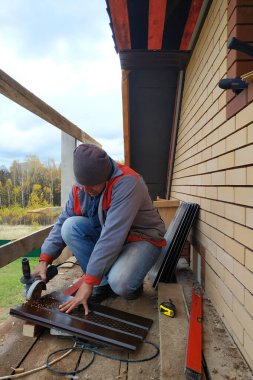 Bir adam metal bir levhayı öğütücüyle keser. 2020