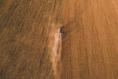 2021 ekonomik kriz zamanlarında, bir sürüngen traktörünün toprağı öğütücüyle öğüttüğü bahar mevsiminde insansız hava aracıyla uçan bir tarlanın üzerinde.