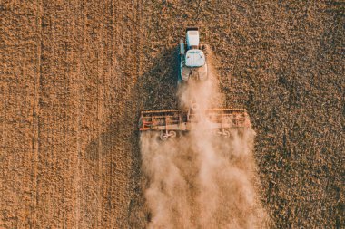 2021 ekonomik kriz zamanlarında, bir sürüngen traktörünün toprağı öğütücüyle öğüttüğü bahar mevsiminde insansız hava aracıyla uçan bir tarlanın üzerinde.