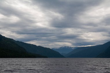 Karla kaplı dağlar, yüksek bulutlu gökyüzü soğuk göl perspektifi, mavi, yeşil, gri resimler.