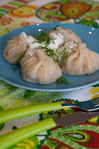 Khinkali: un plato de cocina georgiana con carne picada en el interior, comida en un plato azul - foto de alimentos —  Fotos de Stock