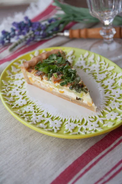 A slice of the finished dish on the plate: a vegetarian shortcrust pastry pie stuffed with vegetables: corn, zucchini, cheese, green onions - food photography — Stock fotografie