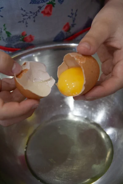 Girl cooks in the kitchen: separating proteins from yolks, breaking an egg - vertical food photo — Stock Photo, Image