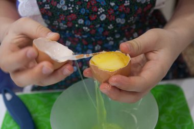 A girl cooks in the kitchen: separating proteins from yolks, breaking an egg - horizontal food photography