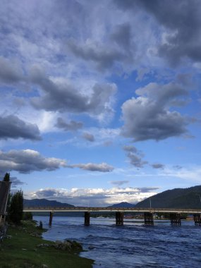 Güzel bulutlar ve gün batımında yağmurdan sonra değişen gökyüzü, Artybash köyündeki bir köprünün manzarası - manzara fotoğrafı
