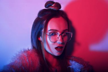 Gözlüklü genç zarif kız moda portre. Renkli arka plan, stüdyo vurdu. Güzel esmer kadın. neon hippi kız. Şık saç ve kırmızı dudaklar kadın ile