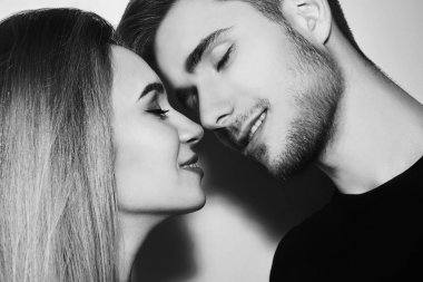Güzel çift öpüşme yakın çekim. Mutlu bir adam ve kız burunlarını ile dokunaklı. Siyah ve beyaz. Sevgililer günü içinde sevgi dolu genç bir çift portresi. Neredeyse bir öpücük. Sevgililer aşk