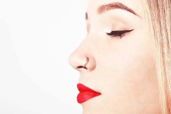 Genç bir kadının visage asılı onun Burun piercing ile closeup. Güzellik genç kız portre. Onun burnuna piercing ile genç çekici kız. Kırmızı dudaklar ve burnuna piercing ile genç kız.