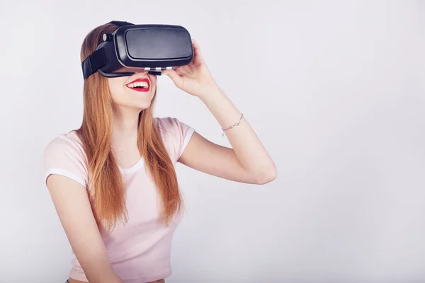 Woman using VR headset. Beautiful girl, VR experience isolated on white. Visual reality concept. Woman getting experience using VR-headset glasses. Excited girl experiencing virtual reality and smile