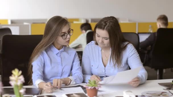 Duas Raparigas Lindas Sentadas Mastigar Papéis Escritório Discutir Sorrir — Vídeo de Stock