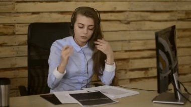 Sevimli kız oturma ve ona müşteri ofiste konuşuyor. Bazı ürünlerde telefon satıyor.