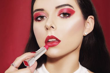 Güzel esmer, kırmızı makyajlı, kırmızı sırtlı.