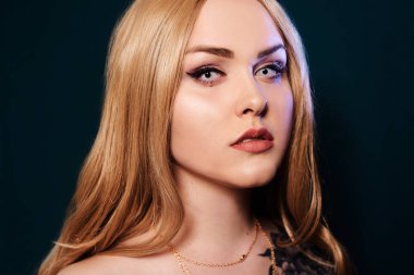 Sarışın, uzun saçlı, kameraya bakıyor. Profesyonel makyaj.