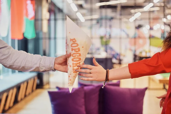 Un homme tient un sac en papier avec du pop-corn sur le fond de la — Photo