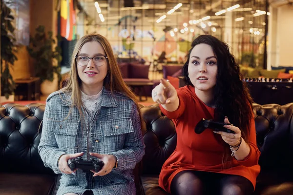 Deux copines jouent à des jeux vidéo, tenant des joysticks dans leur han — Photo