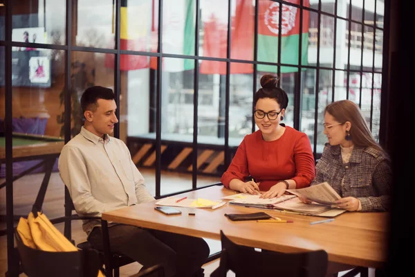 Les étudiants travaillent ensemble sur un projet, les filles et un gars font leurs devoirs — Photo