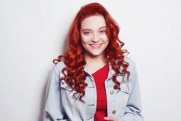 Portrait of beautiful cheerful redhead girl with flying curly ha