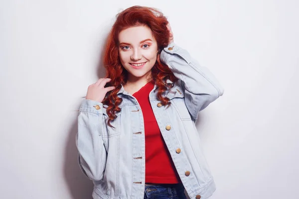 Portrait of beautiful cheerful redhead girl with flying curly ha