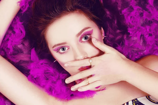 An incredibly beautiful girl with purple fashion makeup lies in — Stock Photo, Image