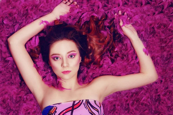 Uma menina incrivelmente bonita com maquiagem rosa moda encontra-se em fe — Fotografia de Stock