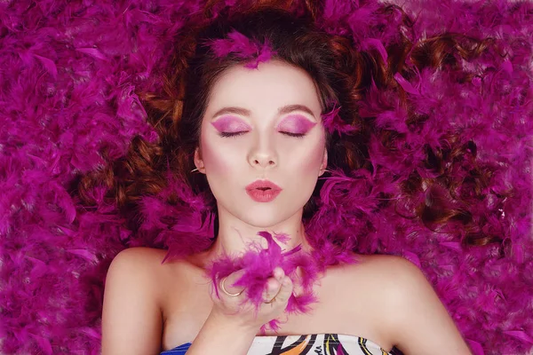 A beautiful girl with professional purple make-up sends an air k — Stock Photo, Image