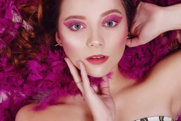 Ein unglaublich schönes Mädchen mit rosa Mode-Make-up liegt in fe — Stockfoto