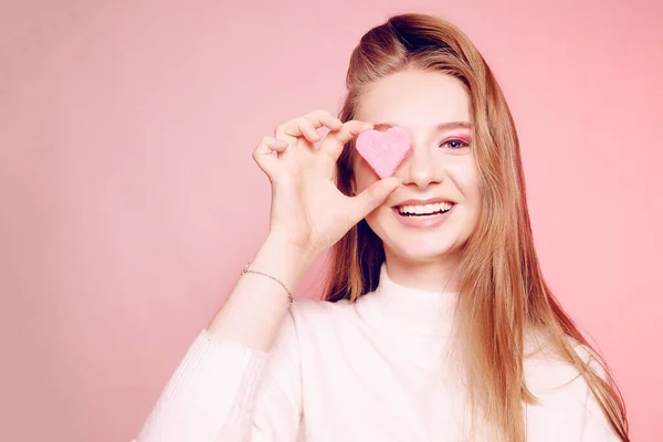 Día de San Valentín, una chica sobre un fondo rosa, cierra su ojo ingenio —  Fotos de Stock