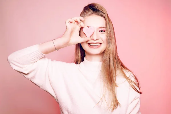 Día de San Valentín, una chica sobre un fondo rosa, cierra su ojo ingenio —  Fotos de Stock