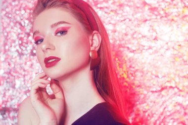 Parlak bir arka planda güzel bir sarışın. Pembe gözlü kız