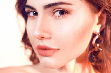 Sarılı saç portresi olan güzel bir esmer. Tarafsız bir torba üzerinde kız