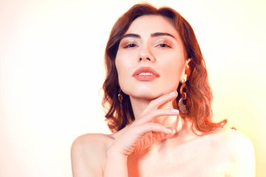 Sarılı saç portresi olan güzel bir esmer. Tarafsız bir torba üzerinde kız