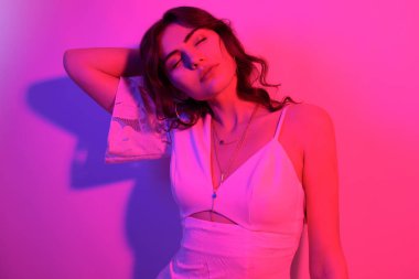 Uzun kıvırcık saçlı, neon rengi dans eden esmer kadın. Profesörü olan bir kız.