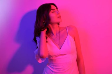 Uzun kıvırcık saçlı, neon rengi dans eden esmer kadın. Profesörü olan bir kız.