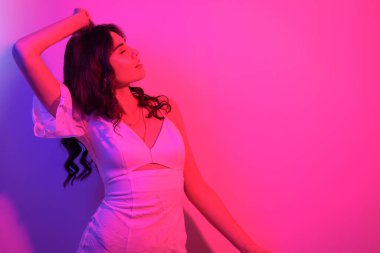 Uzun kıvırcık saçlı, neon rengi dans eden esmer kadın. Profesörü olan bir kız.