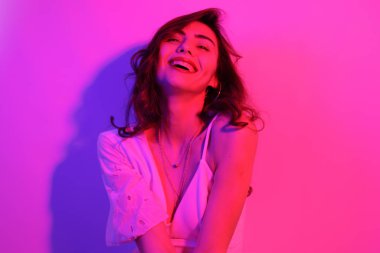 Uzun kıvırcık saçlı, neon rengi dans eden esmer kadın. Profesörü olan bir kız.