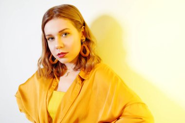 Kısa saçlı güzel bir genç kız kameraya bakar. G