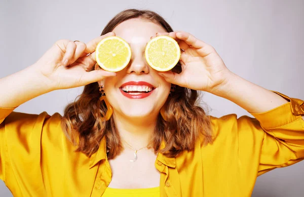 Clouse de uma menina com um limão. Uma menina em um amarelo brilhante dres — Fotografia de Stock