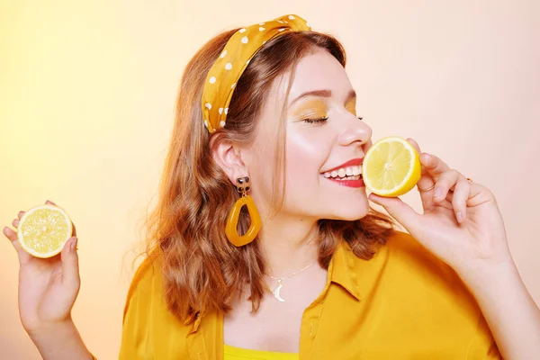 Um belo retrato de uma menina que come um limão, morde uma favela — Fotografia de Stock