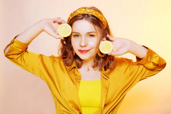 Красивая девушка, желтый макияж, яркие цвета. Девушка держит лимоны — стоковое фото