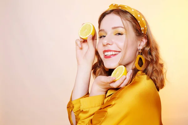 Hermosa chica, maquillaje amarillo, colores brillantes. Chica sostiene limones —  Fotos de Stock