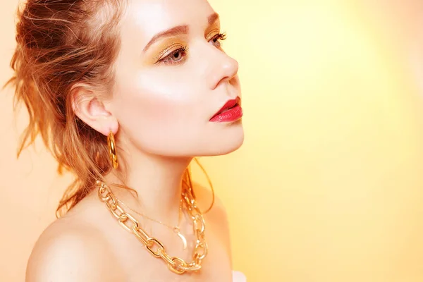 Una joven con maquillaje de oro, una chica con joyas de oro, un oro — Foto de Stock