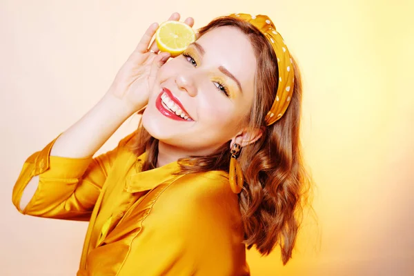 Hermosa chica, maquillaje amarillo, colores brillantes. Chica sostiene limones —  Fotos de Stock