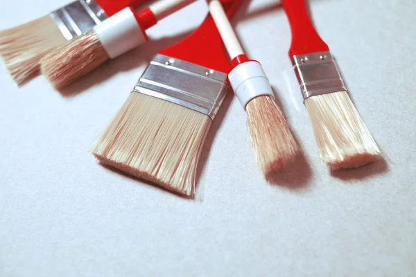 Red paint brushes for painting walls. Red brushes on a white background, clean brushes for painting. Discounts on brushes are worthwhile.