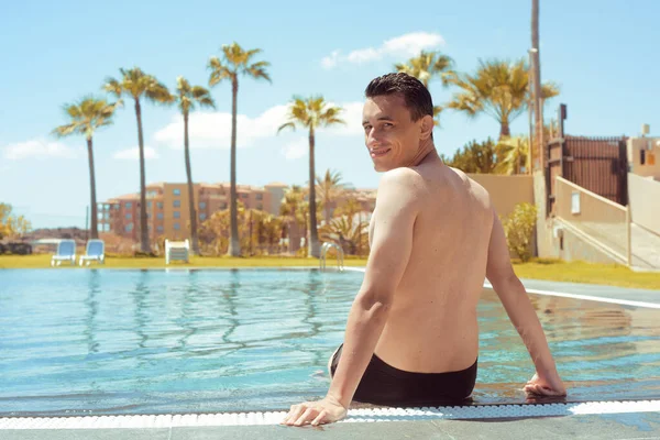 Hombre Sienta Junto Piscina Con Los Pies Agua Día Soleado — Foto de Stock