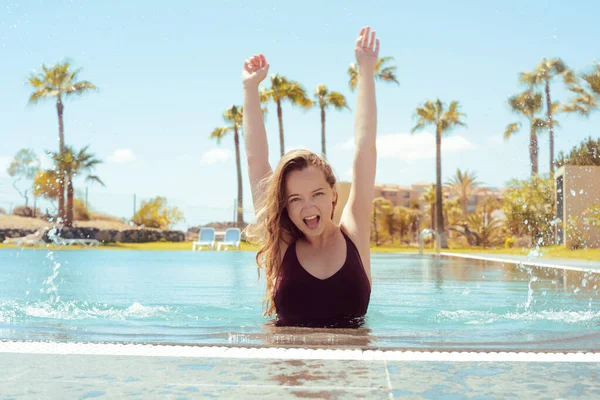 游泳池里快乐的女孩 金发碧眼穿着红色游泳衣 这个女孩喜欢旅行 有棕榈树背景的女孩 — 图库照片