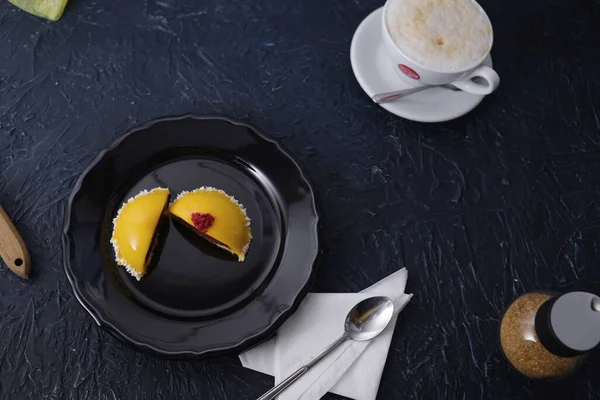 黒プレートと黒の背景に信じられないほど美しい黄色のデザート コーヒーラテ朝食 暗い創造的な背景にレイアウト 朝食の豪華な写真 お菓子 コーヒーを フードフォトのトレーニング — ストック写真