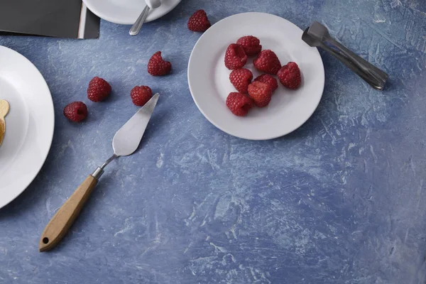 Gorgeous red diet dessert on a biscuit. Raspberries in dessert, raspberries on a blue background. Latte, tomorrow, devices for dessert. Food photo. Breakfast, sweets.