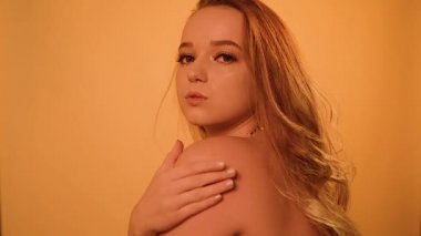 İnciler içindeki göz kamaştırıcı moda kızı. Gözlerinin altında ve boynunda inciler var. Uzun saçlı, poz veren, gülen güzel bir kız. Profesyonel makyaj, takma kirpikler, uzun saçlar, modellik..
