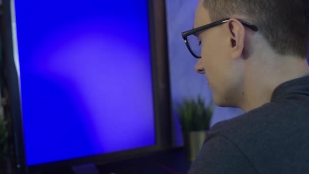 Facet Domu Siedzi Przy Komputerze Pracuje Lub Gra Gry Niebieskim — Wideo stockowe